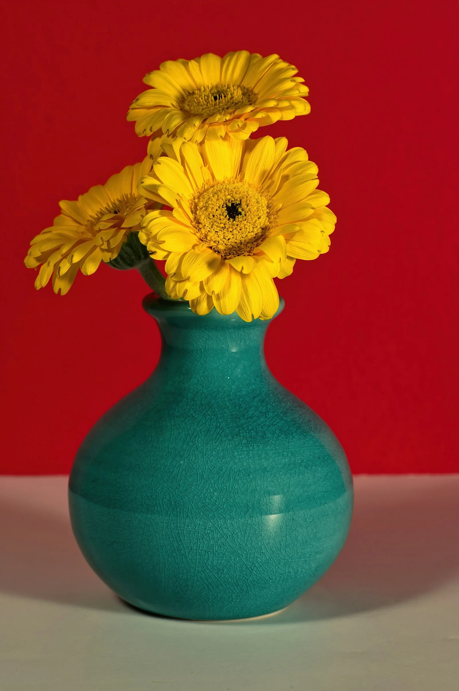 Bright yellow flowers in a green vase
